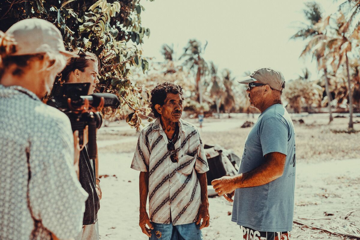 A crew filming a local man on the beach in Rote